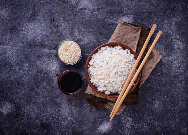 Bowl of boiled rice and chopsticks - Foto, imagen