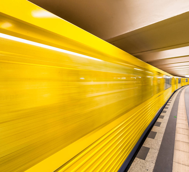 Ein gelber U-Bahn-Zug rast auf eine Stadtstation zu. Geschäfts- und Verkehrskonzept. - Foto, Bild
