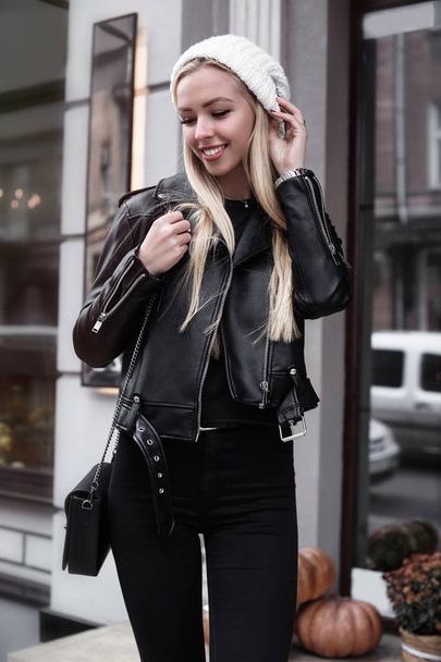Fashionable girl walking in the street,went out from cafe.Happiness highlights her beauty. Attractive young smiling woman looking at side while standing outdoors - Foto, Bild