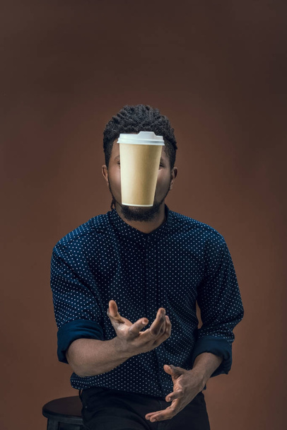 african american man catching disposable coffee cup isolated on brown - Fotoğraf, Görsel