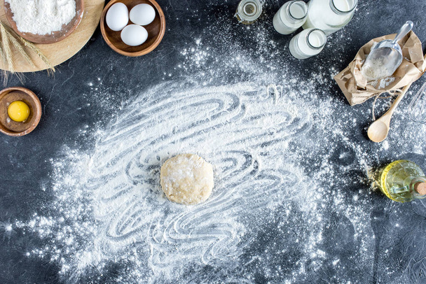 top view of raw dough, baking ingredients and cutlery on marble surface - Fotografie, Obrázek