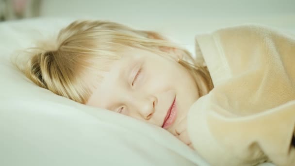 Blonde girl 6 years old sleeps in her bed - Felvétel, videó
