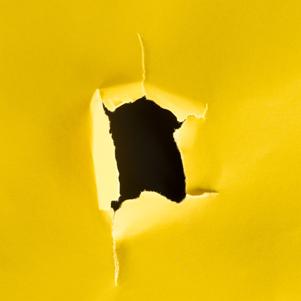 plano plano del agujero en papel amarillo aislado sobre negro
 - Foto, Imagen