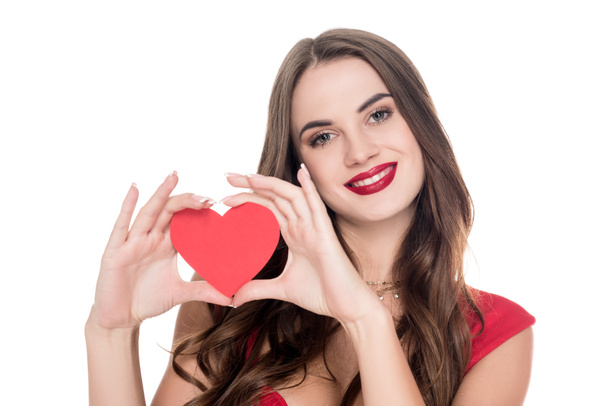 smiling girl in red dress showing paper heart isolated on white, valentines day concept  - Valokuva, kuva