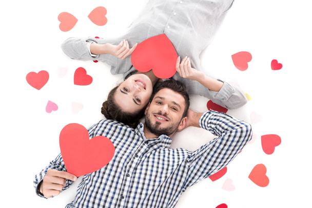 overhead view of couple lying with paper hearts isolated on white, valentines day concept - 写真・画像