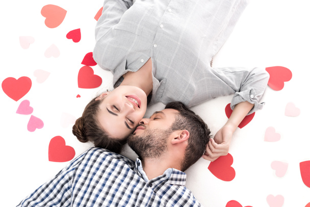overhead view of couple lying with paper hearts isolated on white, valentines day concept - Photo, Image