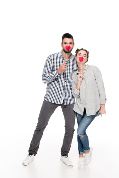 attractive couple covering mouths with paper hearts on white, valentines day concept - Φωτογραφία, εικόνα