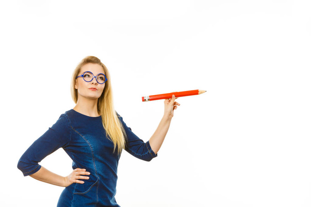 Woman confused thinking, big pencil in hand - Photo, Image