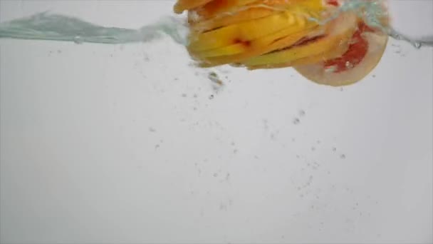 Fresh fruit in water splash, falling grapefruit - Materiał filmowy, wideo