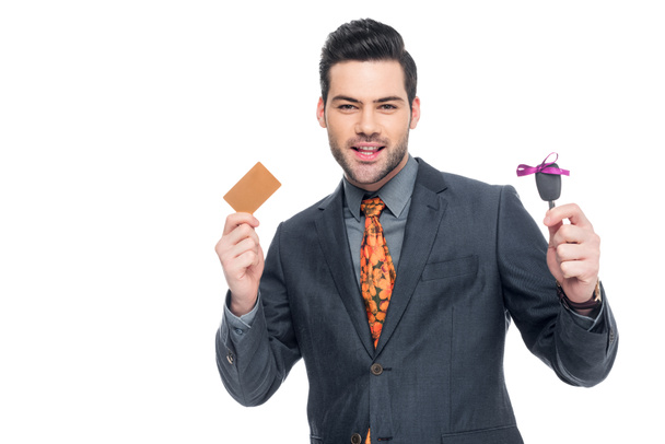 elegant businessman holding credit card and car key, isolated on white - Fotó, kép