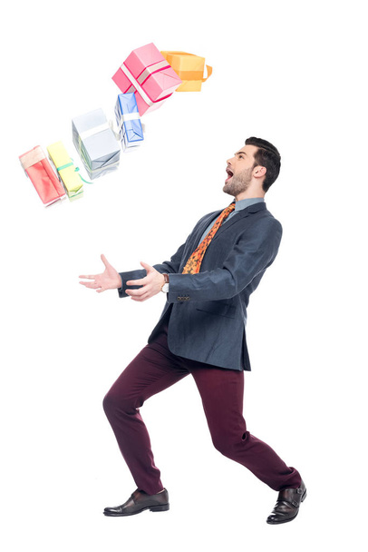 excited bearded man with falling gift boxes, isolated on white - Fotó, kép