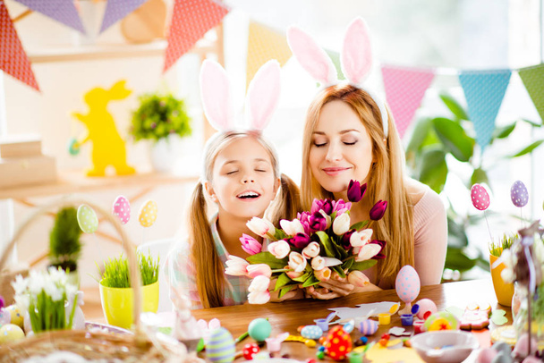 Mother and daughter relaxing on Easter holiday, holding bouquet  - Fotoğraf, Görsel