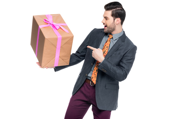 handsome excited man pointing at gift box, isolated on white - Photo, Image