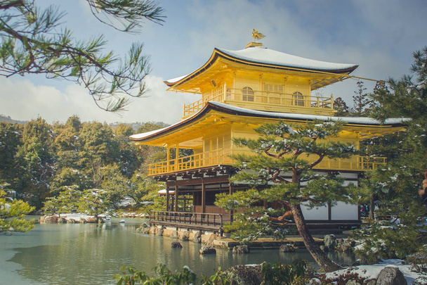 schöne Winterjahreszeit des goldenen Pavillons des Kinkakuji-Tempels mit weißem Schneefall und blauem Himmelshintergrund bei Kyoto, Japan. - Foto, Bild