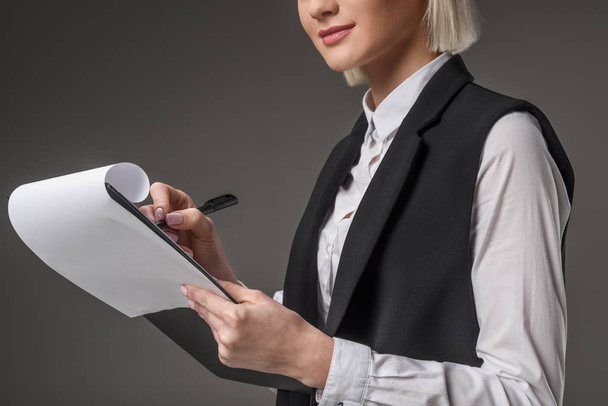 partial view of businesswoman with notepad isolated on grey - Photo, image