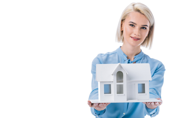 portrait of young real estate agent with house model isolated on white - Foto, afbeelding