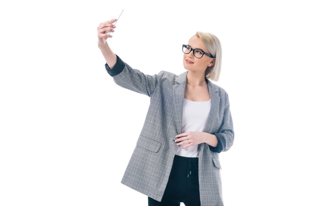 beautiful stylish businesswoman taking selfie on smartphone, isolated on white - Foto, afbeelding