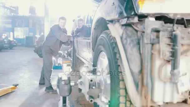 Kfz-Reparatur - Arbeiter bewegt Fahrzeug für Räder Zusammenbruch der Konvergenz - Filmmaterial, Video