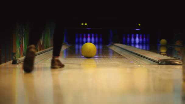No clube de jogo para bowling, o jogador joga uma bola de boliche que derruba skittles. Movimento suave do foco, da frente para trás. O jogador nocauteou a greve e as pernas dançam o
 - Filmagem, Vídeo