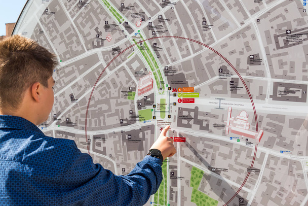 Москва, Россия - 24 июля. 2017 год. Подросток смотрит на карту города
. - Фото, изображение