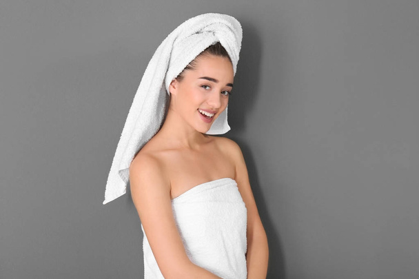 Young woman in white towel on grey background - Foto, Imagen