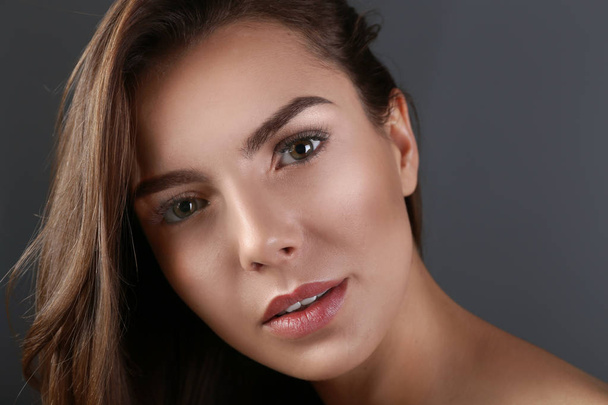 Beautiful young woman with eyelash extensions on grey background - Zdjęcie, obraz