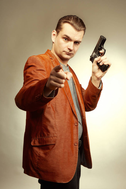 Verbrecher posiert mit Handfeuerwaffe für Porträt im Studio - Foto, Bild