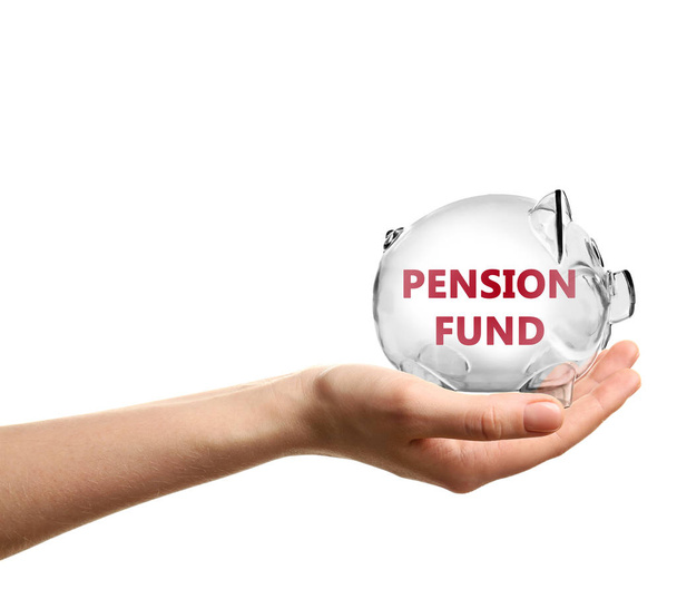 Woman holding piggy bank with text PENSION FUND on white background - Photo, Image