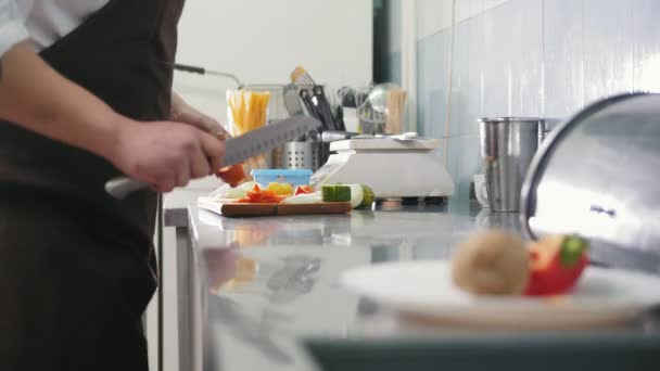 Chef op de keuken van restaurant snijdt fruit voor salade - cooking concept - Video