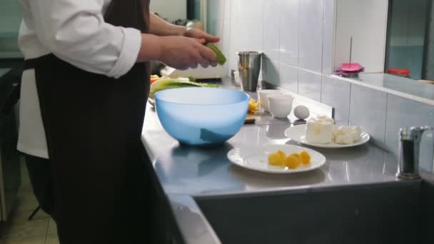 Mies kokki valmistelee salaattia kaupallisessa keittiössä tai ravintolassa
 - Materiaali, video