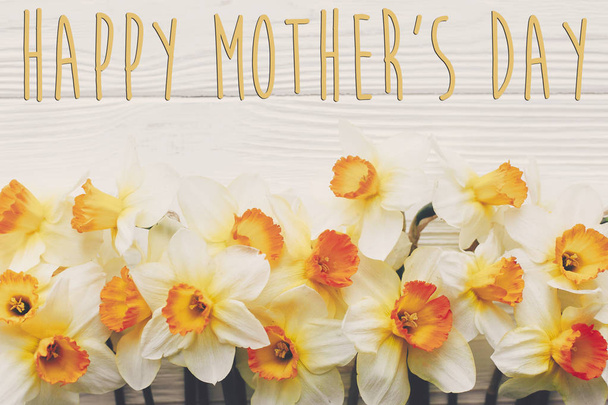 幸せな母の日のテキスト。素朴な木製の背景平面図の花水仙春フラット横たわっていた。スタイリッシュなモダンな幸せな母の日のグリーティング カード。テキストのためのスペース - 写真・画像
