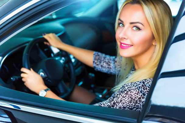 Ευτυχισμένος νεαρή γυναίκα στο σύγχρονο πολυτελές αυτοκίνητο - Φωτογραφία, εικόνα