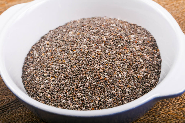 Chia seeds heap in the bowl over wood background - Photo, Image