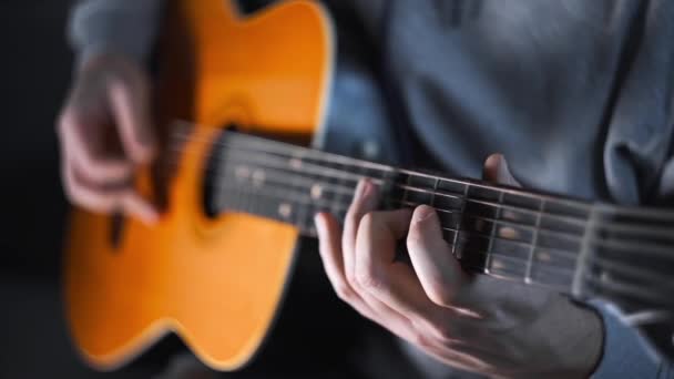 Гітарист грає випадкові акорди на акустичній західній гітарі зі сталевими струнами, вправами та арпеджіо, відео зі звуком, розміщуючи гітару, м'язистий інструмент
 - Кадри, відео