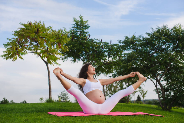 Femme enceinte faisant du yoga à l'extérieur - Photo, image