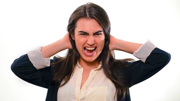 Menina morena típico trabalhador de escritório gritos com as mãos apertadas atrás de sua cabeça
 - Foto, Imagem