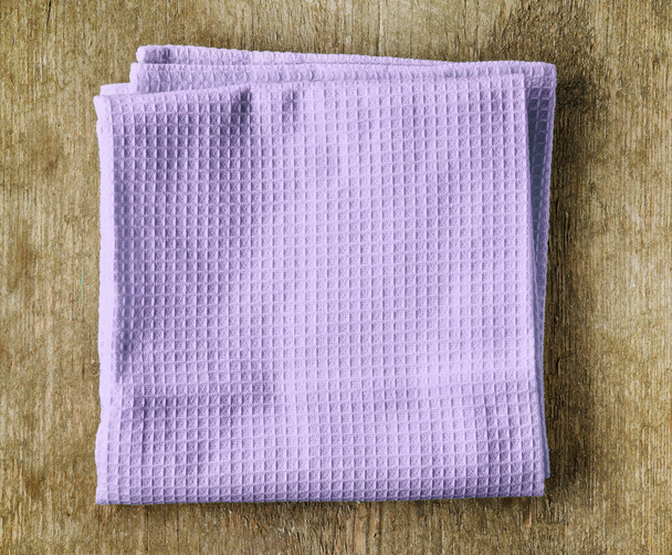 violet towel on wooden table - 写真・画像