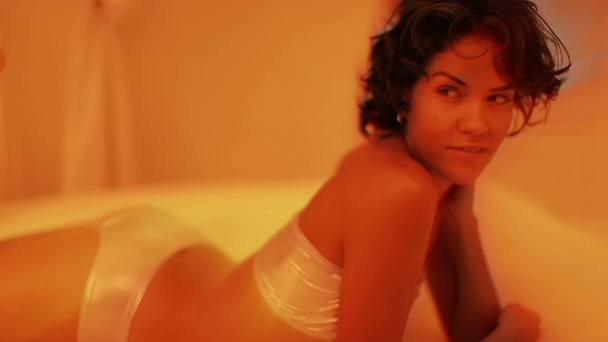 eine sexy Frau im Bikini entspannt sich auf einer Liege am Pool - Filmmaterial, Video