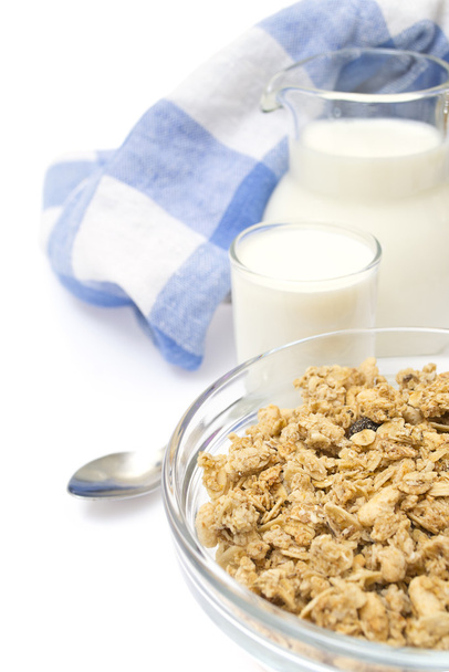 Close-up of a bowl of cereal with a jug of fresh milk, isolated - Photo, Image