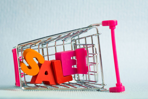 Sale colorful wooden text and shopping cart or supermarket troll - Фото, зображення