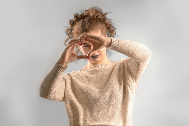 Healthy eyes and vision. Portrait of smiling beautiful happy woman holding heart shaped hands as a love sign near eyes and looking throw it.  - Photo, Image