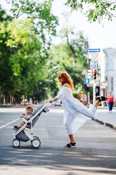 Mutter mit Kinderwagen überquert Straße - Foto, Bild