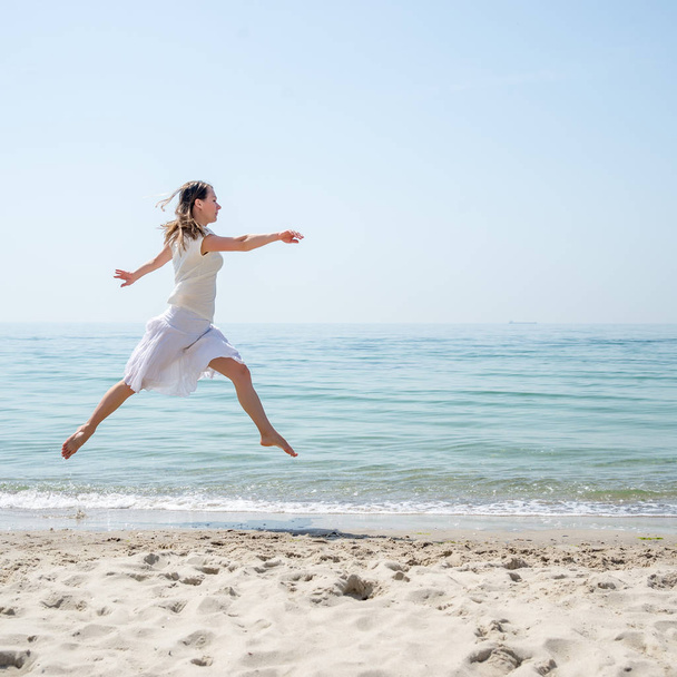 Happy beautiful young girl jumping - 写真・画像