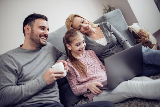 Mooie familie kijken film op laptop thuis - Foto, afbeelding