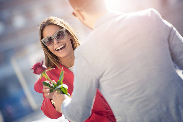 Romantické rande. Mladý muž dává růže se svou přítelkyní. - Fotografie, Obrázek