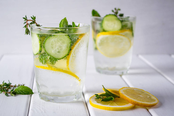Освежающий огуречный коктейль, лимонад, детоксикационная вода в стаканах на белом фоне. Летний напиток
. - Фото, изображение