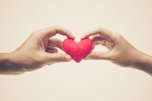 Las manos de una pareja sosteniendo como un corazón rojo juntas / Amor y romance en el concepto del día de San Valentín
                                   - Foto, imagen
