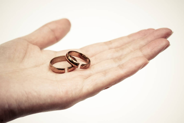 Hand mit gebrochenen Ringen / Scheidung und Beziehungsende - Foto, Bild
