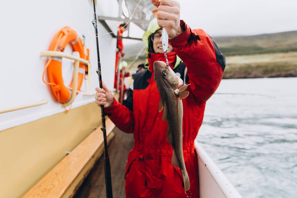 Giovane pescatore maschio con pesci in mano
 - Foto, immagini