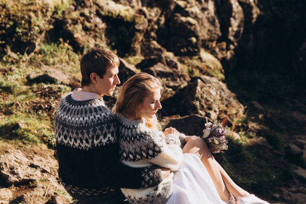 junges schönes Paar sitzt auf einem Berg und sonnt sich in der Sonne - Foto, Bild